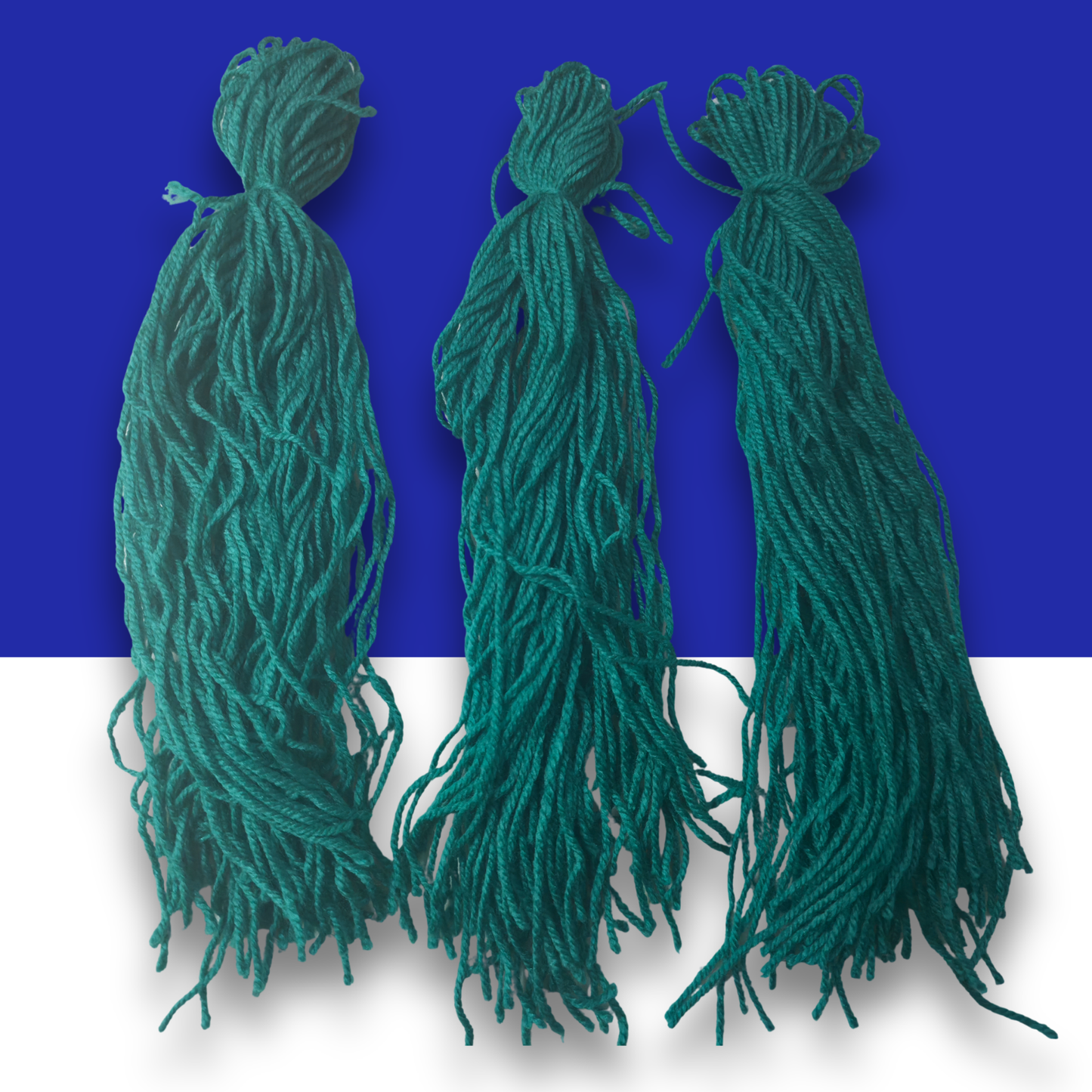 Three green wool spawning mops for fish breeding on a blue and white background