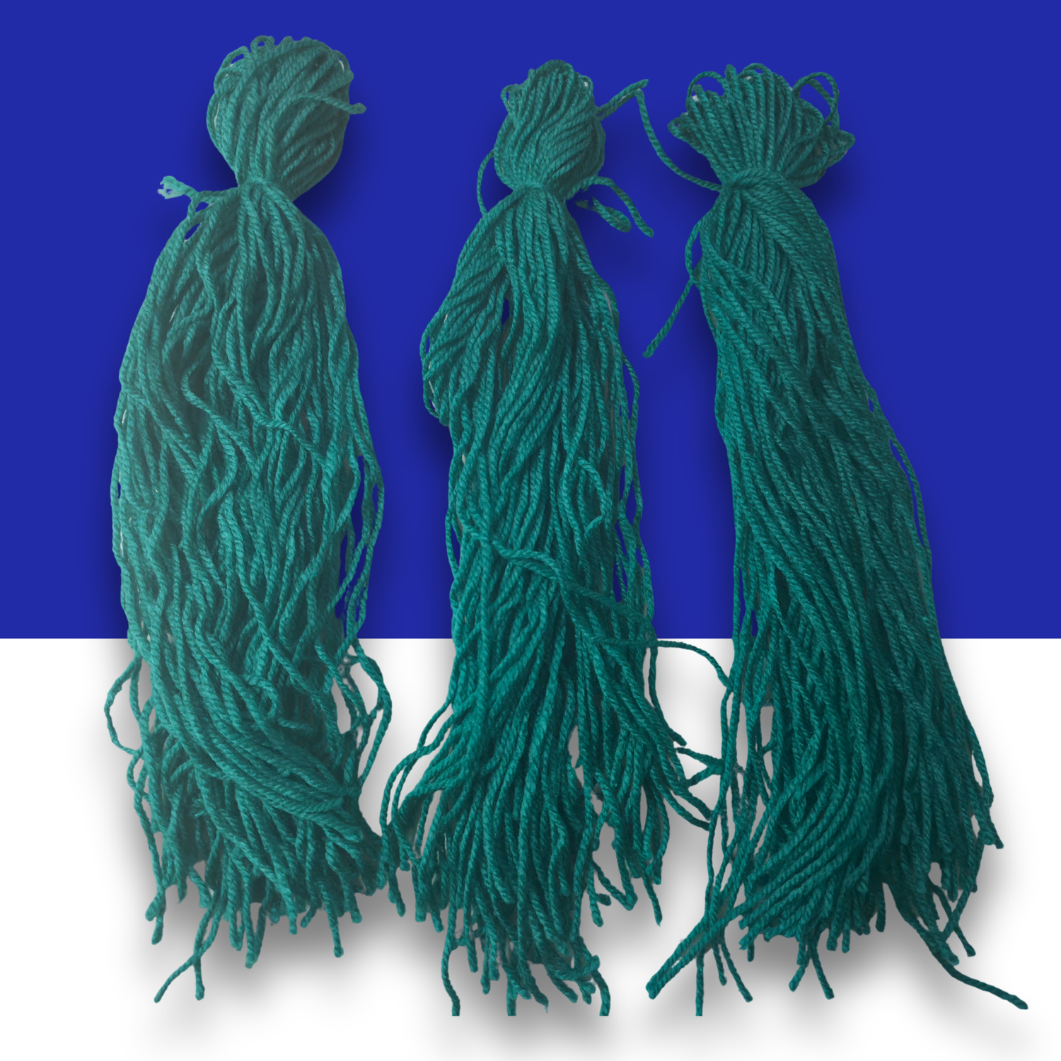Three green wool spawning mops for fish breeding on a blue and white background