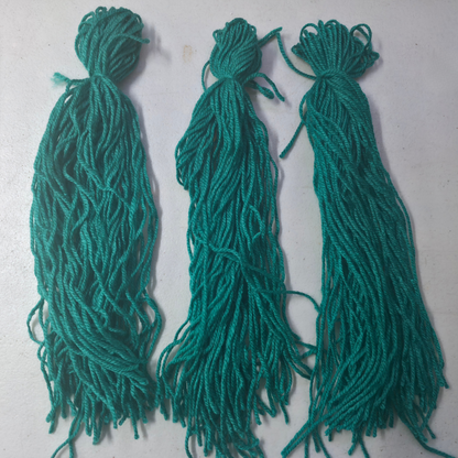 Three green spawning mops for fish breeding on a light gray background